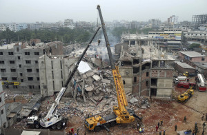 FILE - In this April 29, 2013 file photo, the collapsed Rana Plaza garment factory building is seen from a building nearby as a crane prepares to lift the fallen ceiling in Savar, near Dhaka, Bangladesh. A Bangladeshi garment industry leader on Saturday, April 18, 2015, guardedly welcomed Italian retailer Benetton's pledge of more than $1 million to victims of the factory collapse that killed over 1,100 people two years ago, saying it had come late but was appreciated. (AP Photo/Wong Maye-E, File)